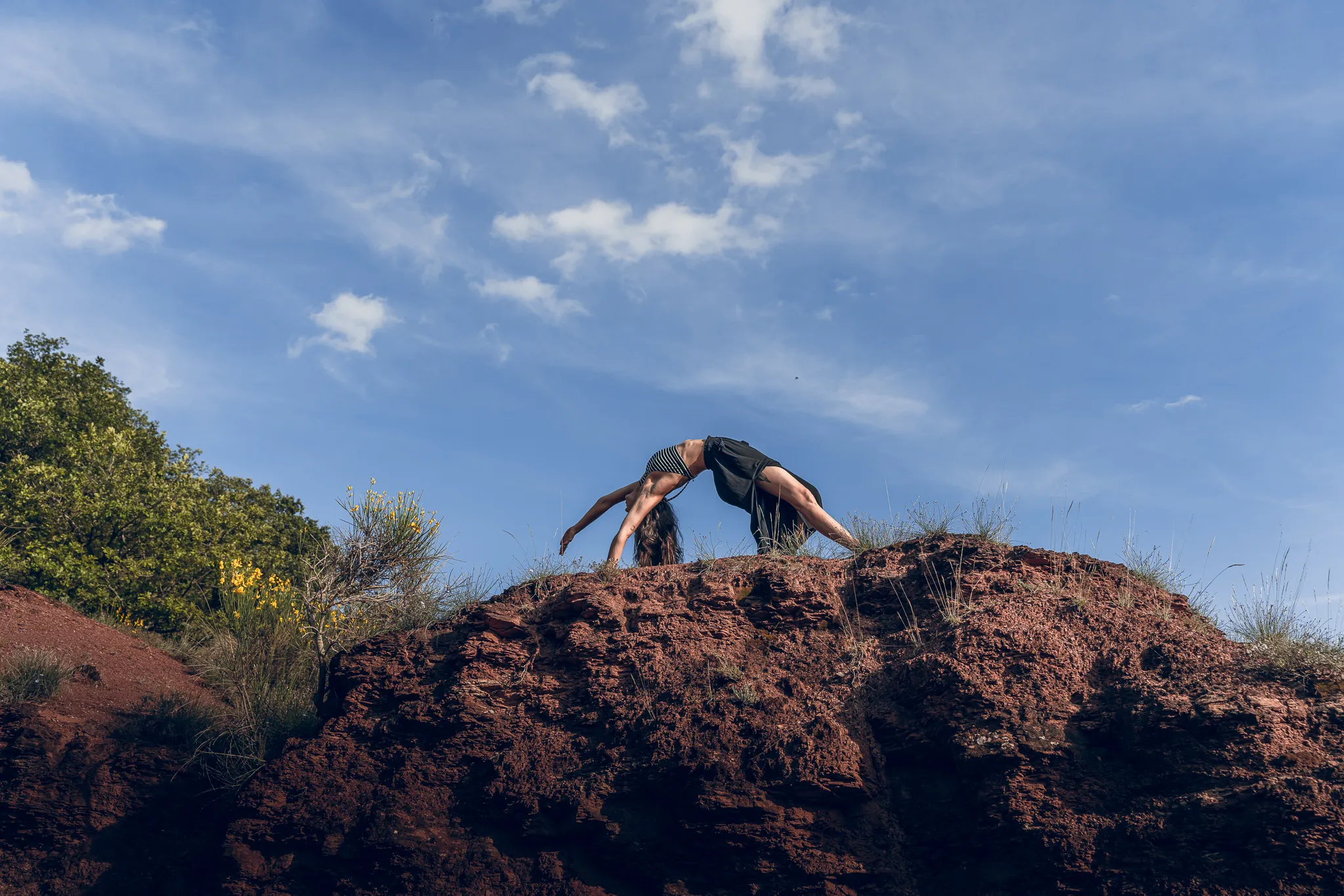Marylou Forges, professeure de yoga et fondatrice de Yoga Le Refuge à Saint-Rome-de-Tarn, réalisant une posture cambrée au Rougier en plein air dans l’Aveyron