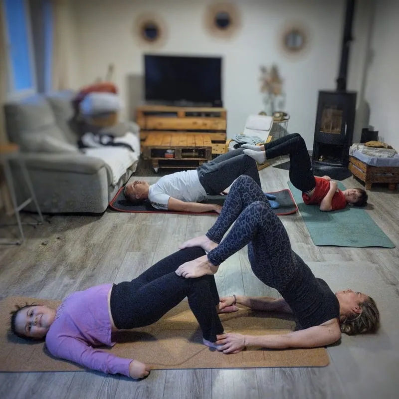 Marylou Forges, fondatrice de Yoga Le Refuge à Saint-Rome-de-Tarn, animant un cours privé de yoga à domicile avec 4 participants, en posture de pont